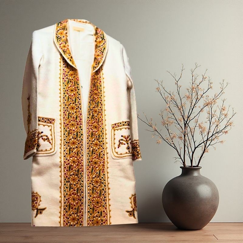 Traditional women's embroidered cloak in natural wool, handcrafted with geometric embroidery patterns, connecting modern wearers to Chitral's ancient artisan communities